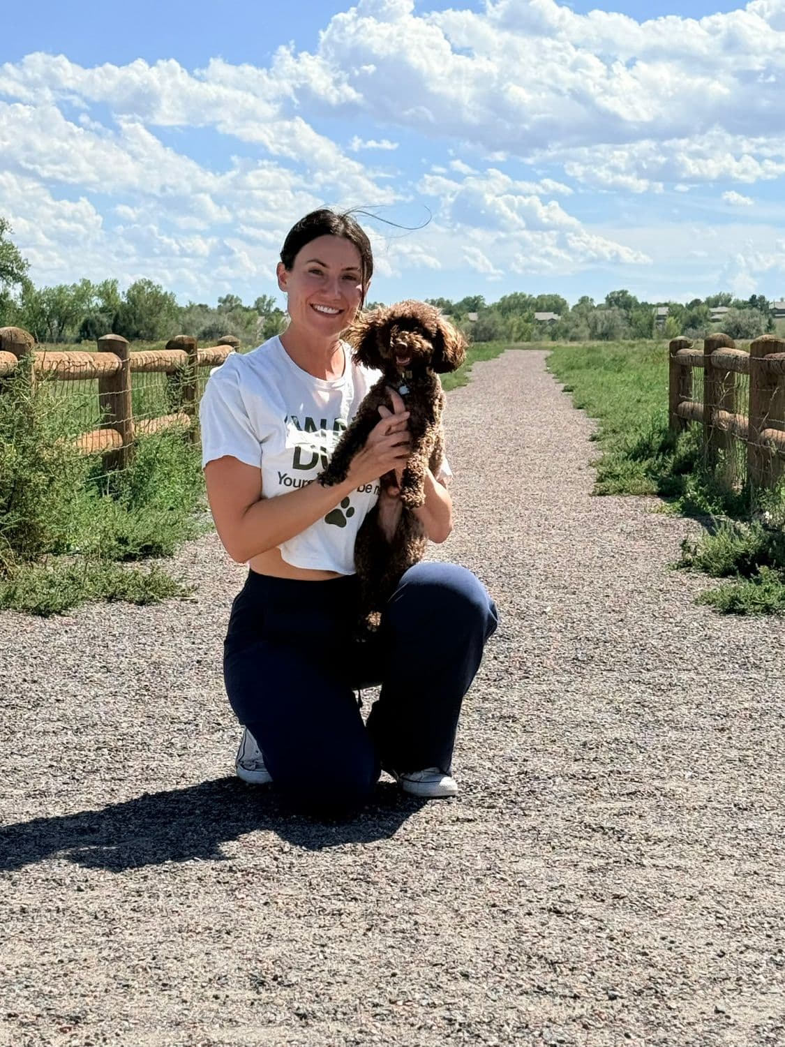 Anna holding Cocoa on a trail path